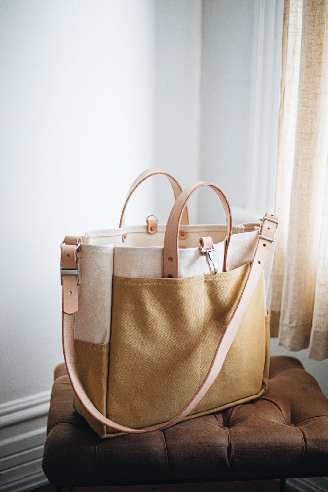 A mustard canvas tote with leather handles