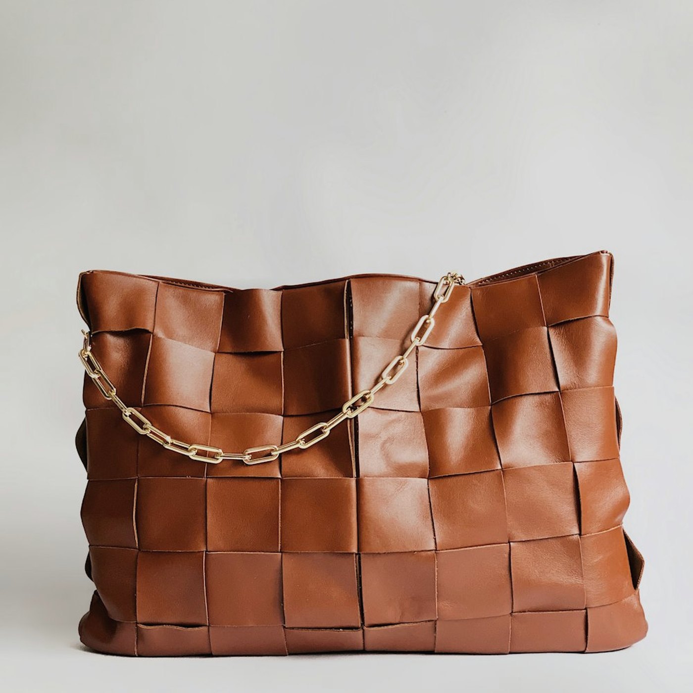 Brown woven leather tote with a gold chain handle